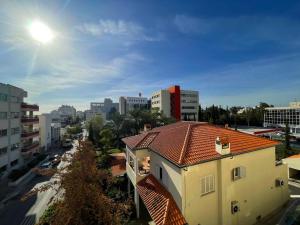 a building with a red roof in a city at Comfort Stay in Nicosia - Aglantzia RIK in Nicosia