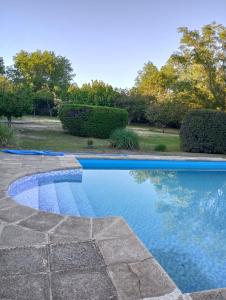 a swimming pool with blue water in a yard at Sauces Las Chacras in Juana Koslay  +20 photos