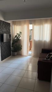 a living room with a couch and a potted plant at Residencial Maldonado Eckert - APTO 199 E - Praia Grande in São Francisco do Sul