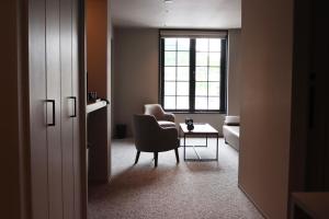 a room with a chair and a table and a window at GEMS YUFUIN Hotel and Spa Cafe Bar in Yufu