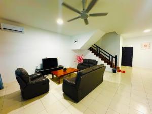 a living room with two chairs and a ceiling fan at HmHome-five in Sibu