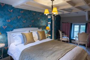 a bedroom with a large bed with floral wallpaper at West Lyn Farm Bed & Breakfast in Lynton +10 photos
