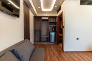 a living room with a couch and a refrigerator at Rafiki Rooms in Nydri