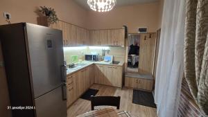 a kitchen with a refrigerator and a man standing in the kitchen at Suite Roma 3 in Velingrad