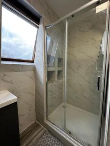 a shower with a glass door in a bathroom at MileEnd 4 large master bedroom in London