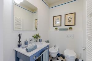 a bathroom with a blue sink and a toilet at Gimber Smart and Luxury 2 bedrooms 2 bathrooms in Lucca