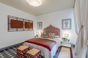 a bedroom with a bed with two ottomans at Gimber Smart and Luxury 2 bedrooms 2 bathrooms in Lucca