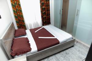 a small bed in a room with a window at MARA Apartments in Gisenyi