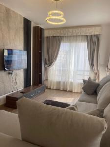 ein Wohnzimmer mit Sofa und Fernseher in der Unterkunft Family 2 bedrooms B6 group 62 in Madinaty