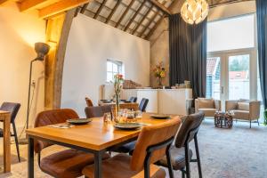 a dining room with a wooden table and chairs at Hof Olmenstein in Goes