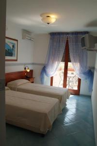 2 camas en una habitación de hotel con ventana en Hotel Morgan, en Manduria