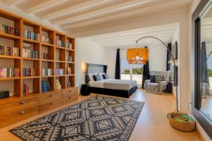 a living room with a bed and a book shelf at Myconian Platinum Senior & Deluxe Villas in Kalafatis