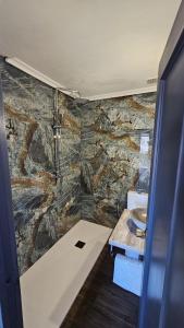 bagno con parete in pietra e lavandino di Hotel Restaurante EL PATAS a Corral de Almaguer Altre 22 foto