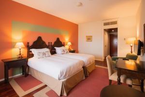 a hotel room with a large bed and a desk at Pousada Valença do Minho in Valença