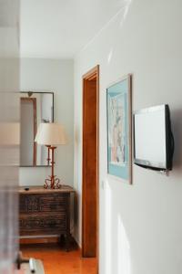 a room with a television and a table with a lamp at Pousada de Valença in Valença