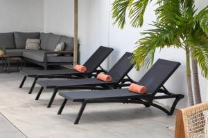four black lounge chairs in a living room with a couch at Villa Sol A Luna - Mambo Beach in Willemstad