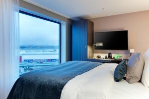 a bedroom with a large bed with a large window at Clarion Hotel Air in Sola