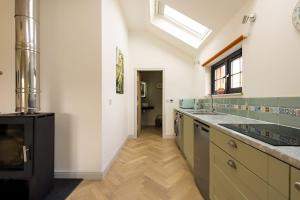 a kitchen with a sink and a stove at Bream Loft, dog friendly, wood burner, walking distance to beach in Falmouth +37 photos