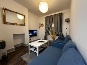 a living room with a blue couch and a table at MileEnd 4 large master bedroom in London