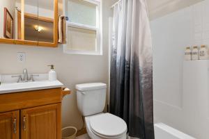 Un baño con inodoro, lavabo y ducha. en Cozy mountain cabin, Hot Tub, BBQ, Games by MariamsBnb, en Big Bear City 51 fotos más