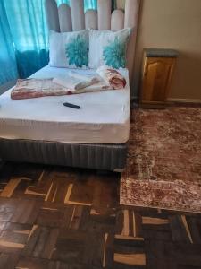 a bedroom with a bed in a room with a floor at RMguest house in Zeerust