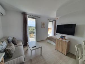 a living room with a couch and a flat screen tv at Hi Hellas 4 in Artemida