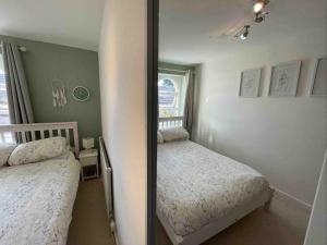 una piccola camera con due letti e uno specchio di Cottage Apartment Near Lancaster University a Galgate