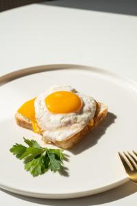 an egg on a piece of bread on a plate at Bubbles of luxury Dublagadi Beach in Sindhia