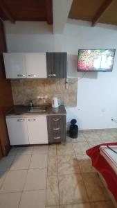 Una cocina con gabinetes blancos y un fregadero. en Guenechen familiar, en Río Colorado