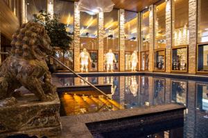 a swimming pool with a statue in a building at Alexander Hotel in Noordwijk aan Zee