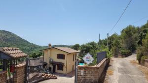 mały dom z płotem obok drogi w obiekcie Villa Dolce Havana con piscina w mieście Sperlonga