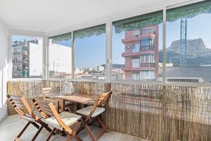 un tavolo e sedie su un balcone con una grande finestra di LovelyLoft Mercado ad Alicante