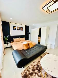 a bedroom with a bed with a black leather couch at Vibe Phuket Relax in Town in Phuket Town
