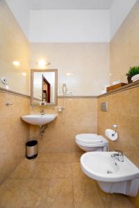 a bathroom with a sink and a toilet and a mirror at Ventus Rosa Apartments in Krakow