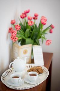 a table with two cups of tea and cookies at Ventus Rosa Apartments in Krakow