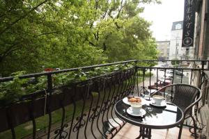 a table with a cup of coffee on a balcony at Ventus Rosa Apartments in Krakow