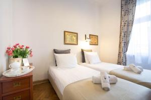 two beds in a hotel room with towels on them at Ventus Rosa Apartments in Krakow