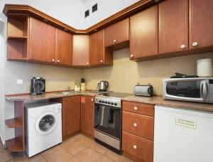 a kitchen with a microwave and a washer and dryer at Ventus Rosa Apartments in Krakow
