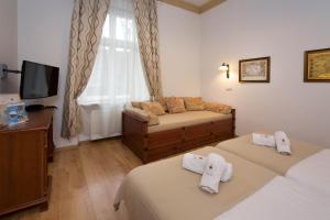a hotel room with two beds and a television at Ventus Rosa Apartments in Krakow