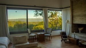 a living room with a large window with a view at Merlín Art Lodge in Atos Pampa
