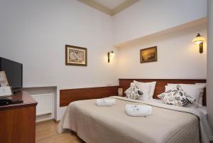 a bedroom with a bed with two towels on it at Ventus Rosa Apartments in Krakow