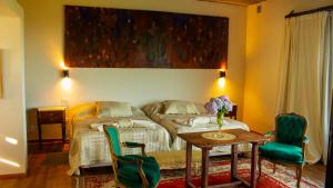 a bedroom with a bed and a table and chairs at Merlín Art Lodge in Atos Pampa