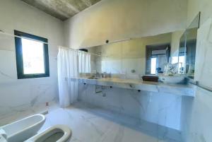 a large bathroom with two sinks and a toilet at Merlín Art Lodge in Atos Pampa
