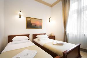 two twin beds in a room with a window at Ventus Rosa Apartments in Krakow