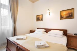 a bedroom with two beds with towels on them at Ventus Rosa Apartments in Krakow