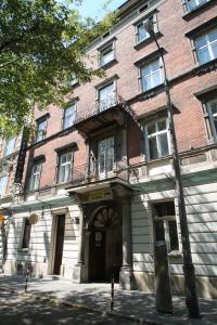 a large brick building with a door and balcony at Ventus Rosa Apartments in Krakow