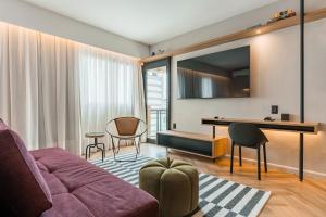 a living room with a couch and a table at Cyclinn Brooklin Novo in São Paulo