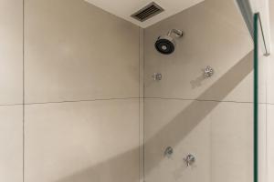 a shower with a glass door with a shower head at Cyclinn Brooklin Novo in São Paulo