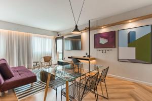a living room with a glass table and chairs at Cyclinn Brooklin Novo in São Paulo