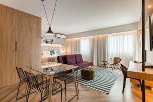 a living room with a table and chairs and a bedroom at Cyclinn Brooklin Novo in São Paulo
